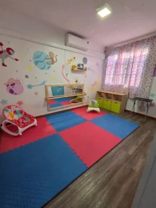 Sala de estimulación temprana con mats de seguridad y decoración infantil temática